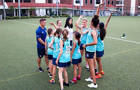 Testimonial of Coach with students playing touch rugby